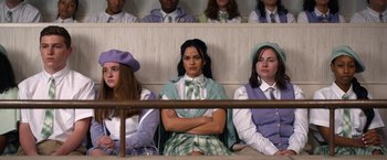 Movie still from “Do Revenge” (2022), directed by Jennifer Kaytin Robinson – A group of people sitting in a row of seats; Medium shot, High angle