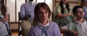 Movie still from “Do Revenge” (2022), directed by Jennifer Kaytin Robinson – A woman with blue eyes wearing a blue tie; Close Up shot, Over the shoulder angle