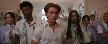 Movie still from “Do Revenge” (2022), directed by Jennifer Kaytin Robinson – A group of young people standing in a room; Medium shot, Low angle