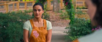 Movie still from “Do Revenge” (2022), directed by Jennifer Kaytin Robinson – A woman in an apron standing in front of a tree; Close Up shot, Over the shoulder angle