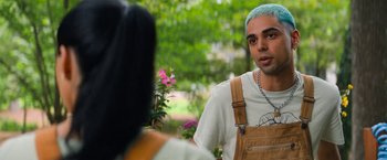 Movie still from “Do Revenge” (2022), directed by Jennifer Kaytin Robinson – A man with blue hair talking to a woman in an outdoor setting; Medium shot, Over the shoulder angle