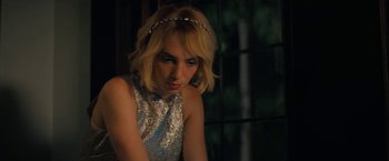 Movie still from “Do Revenge” (2022), directed by Jennifer Kaytin Robinson – A woman with blonde hair wearing a silver dress; Close Up shot, Over the shoulder angle