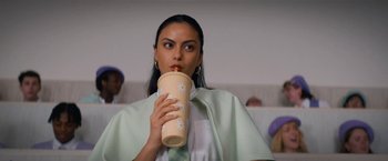 Movie still from “Do Revenge” (2022), directed by Jennifer Kaytin Robinson – A woman is holding a coffee cup up to her mouth; Close Up shot, Low angle