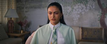 Movie still from “Do Revenge” (2022), directed by Jennifer Kaytin Robinson – A woman in a white shirt and a green tie; Close Up shot, Over the shoulder angle