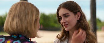 Movie still from “Do Revenge” (2022), directed by Jennifer Kaytin Robinson – Two young women talking to each other in a park; Close Up shot, Over the shoulder angle