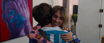 Movie still from “Do Revenge” (2022), directed by Jennifer Kaytin Robinson – Two people hugging each other in a room; Medium shot, Over the shoulder angle