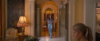 Movie still from “Do Revenge” (2022), directed by Jennifer Kaytin Robinson – A woman walking through a hallway in a house; Wide shot, Low angle