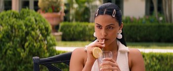 Movie still from “Do Revenge” (2022), directed by Jennifer Kaytin Robinson – A beautiful woman holding a glass of water and a lemon; Close Up shot, Over the shoulder angle