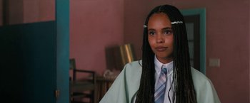 Movie still from “Do Revenge” (2022), directed by Jennifer Kaytin Robinson – A woman with long braids wearing a suit and tie; Close Up shot, Over the shoulder angle