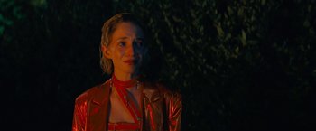 Movie still from “Do Revenge” (2022), directed by Jennifer Kaytin Robinson – A woman in a red dress is standing in front of a tree; Close Up shot, Over the shoulder angle