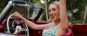Movie still from “Do Revenge” (2022), directed by Jennifer Kaytin Robinson – A beautiful young woman driving a red car; Close Up shot, Low angle