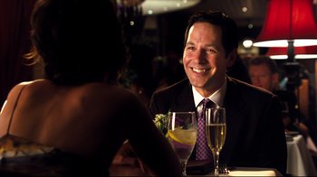 Movie still from “Dinner for Schmucks” (2010), directed by Jay Roach – A man sitting at a table with a glass of wine; Close Up shot, Over the shoulder angle