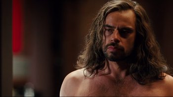 Movie still from “Dinner for Schmucks” (2010), directed by Jay Roach – A man with long hair and a bare chest; Close Up shot, Over the shoulder angle