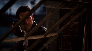 Movie still from “Dinner for Schmucks” (2010), directed by Jay Roach – A man standing next to a wooden structure; Medium shot, Over the shoulder angle