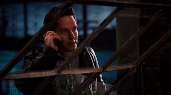 Movie still from “Dinner for Schmucks” (2010), directed by Jay Roach – A man talking on a cell phone while sitting in a chair; Medium shot, Over the shoulder angle
