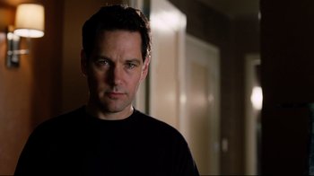 Movie still from “Dinner for Schmucks” (2010), directed by Jay Roach – A person wearing a black t - shirt; Close Up shot, Over the shoulder angle