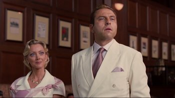 Movie still from “Dinner for Schmucks” (2010), directed by Jay Roach – A man in a white suit standing next to a woman in a white suit; Medium shot, Low angle