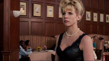 Movie still from “Dinner for Schmucks” (2010), directed by Jay Roach – A woman in a black dress and pearls in a restaurant; Medium shot, Low angle