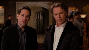 Movie still from “Dinner for Schmucks” (2010), directed by Jay Roach – Two men standing next to each other in front of a building; Medium shot, Over the shoulder angle