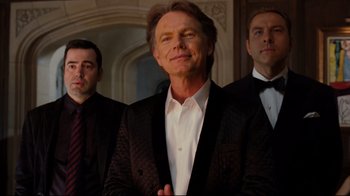 Movie still from “Dinner for Schmucks” (2010), directed by Jay Roach – A group of men standing next to each other in front of a wall; Medium shot, Low angle