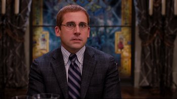 Movie still from “Dinner for Schmucks” (2010), directed by Jay Roach – A person wearing a suit and tie; Close Up shot, Over the shoulder angle