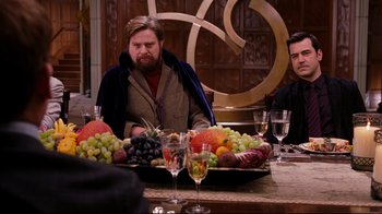 Movie still from “Dinner for Schmucks” (2010), directed by Jay Roach – A man sitting at a table with a tray of fruit; Medium shot, Over the shoulder angle
