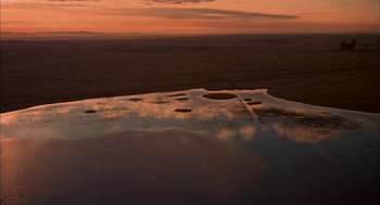 Movie still from “Dirty Mary Crazy Larry” (1974), directed by John Hough – An aerial view of a body of water at sunset; Extreme Wide shot, High angle