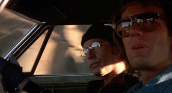 Movie still from “Dirty Mary Crazy Larry” (1974), directed by John Hough – A man and a woman sitting in a car looking out the window; Close Up shot, Low angle