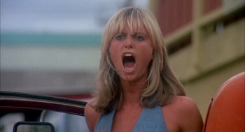Movie still from “Dirty Mary Crazy Larry” (1974), directed by John Hough – A woman with long blonde hair and a blue top is screaming; Close Up shot, Low angle