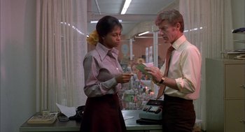 Movie still from “Dirty Mary Crazy Larry” (1974), directed by John Hough – A man and a woman are looking at some bills; Medium shot, Low angle