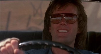 Movie still from “Dirty Mary Crazy Larry” (1974), directed by John Hough – A person wearing sunglasses driving a car; Close Up shot, Low angle