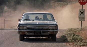 Movie still from “Dirty Mary Crazy Larry” (1974), directed by John Hough – Two people are sitting in the back seat of a car; Wide shot, Over the shoulder angle