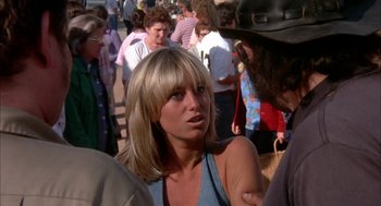 Movie still from “Dirty Mary Crazy Larry” (1974), directed by John Hough – A woman is talking to a man in a crowd of onlookers; Close Up shot, Over the shoulder angle