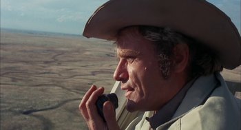 Movie still from “Dirty Mary Crazy Larry” (1974), directed by John Hough – An older man wearing a cowboy hat talking on a cell phone; Close Up shot, Low angle