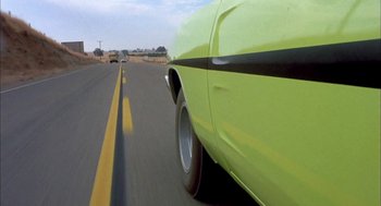 Movie still from “Dirty Mary Crazy Larry” (1974), directed by John Hough – The rear end of a car on the road; Wide shot, Low angle