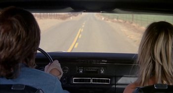 Movie still from “Dirty Mary Crazy Larry” (1974), directed by John Hough – A man driving a car on a road; Wide shot, High angle