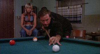 Movie still from “Dirty Mary Crazy Larry” (1974), directed by John Hough – A man and a woman are playing a game of billiards; Medium shot, Over the shoulder angle