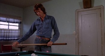 Movie still from “Dirty Mary Crazy Larry” (1974), directed by John Hough – A man holding a pool stick while standing in front of a pool table; Medium shot, Low angle