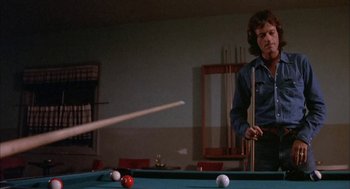 Movie still from “Dirty Mary Crazy Larry” (1974), directed by John Hough – A man is playing a game of billiards; Medium shot, Low angle