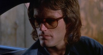 Movie still from “Dirty Mary Crazy Larry” (1974), directed by John Hough – A person wearing sunglasses; Close Up shot, Low angle