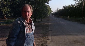 Movie still from “Dirty Mary Crazy Larry” (1974), directed by John Hough – An older man standing on the side of a road; Medium shot, Low angle