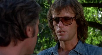 Movie still from “Dirty Mary Crazy Larry” (1974), directed by John Hough – A man wearing glasses talking to another man wearing glasses; Close Up shot, Over the shoulder angle