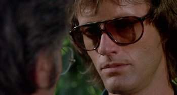 Movie still from “Dirty Mary Crazy Larry” (1974), directed by John Hough – A person wearing a pair of sunglasses; Close Up shot, Over the shoulder angle