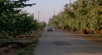 Movie still from “Dirty Mary Crazy Larry” (1974), directed by John Hough – A car driving down the middle of a street; Extreme Wide shot, High angle