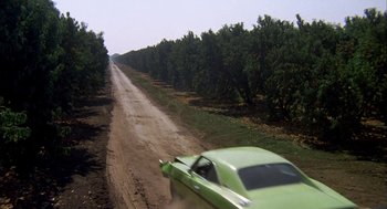 Movie still from “Dirty Mary Crazy Larry” (1974), directed by John Hough – A car driving down a dirt road next to trees; Extreme Wide shot, High angle