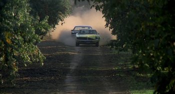 Movie still from “Dirty Mary Crazy Larry” (1974), directed by John Hough – A couple of cars driving down a dirt road; Wide shot, High angle