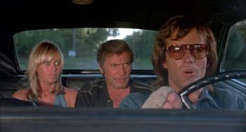 Movie still from “Dirty Mary Crazy Larry” (1974), directed by John Hough – A group of people sitting in the back of a car; Medium shot, Low angle