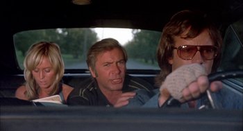 Movie still from “Dirty Mary Crazy Larry” (1974), directed by John Hough – Three people sitting in a car looking angry; Medium shot, Low angle