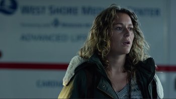 Movie still from “Do You Believe?” (2015), directed by Jon Gunn – A woman with curly blonde hair standing in front of a wall; Close Up shot, Low angle