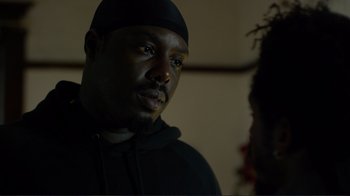 Movie still from “Do You Believe?” (2015), directed by Jon Gunn – A man wearing a black hat and a black hoodie; Close Up shot, Over the shoulder angle